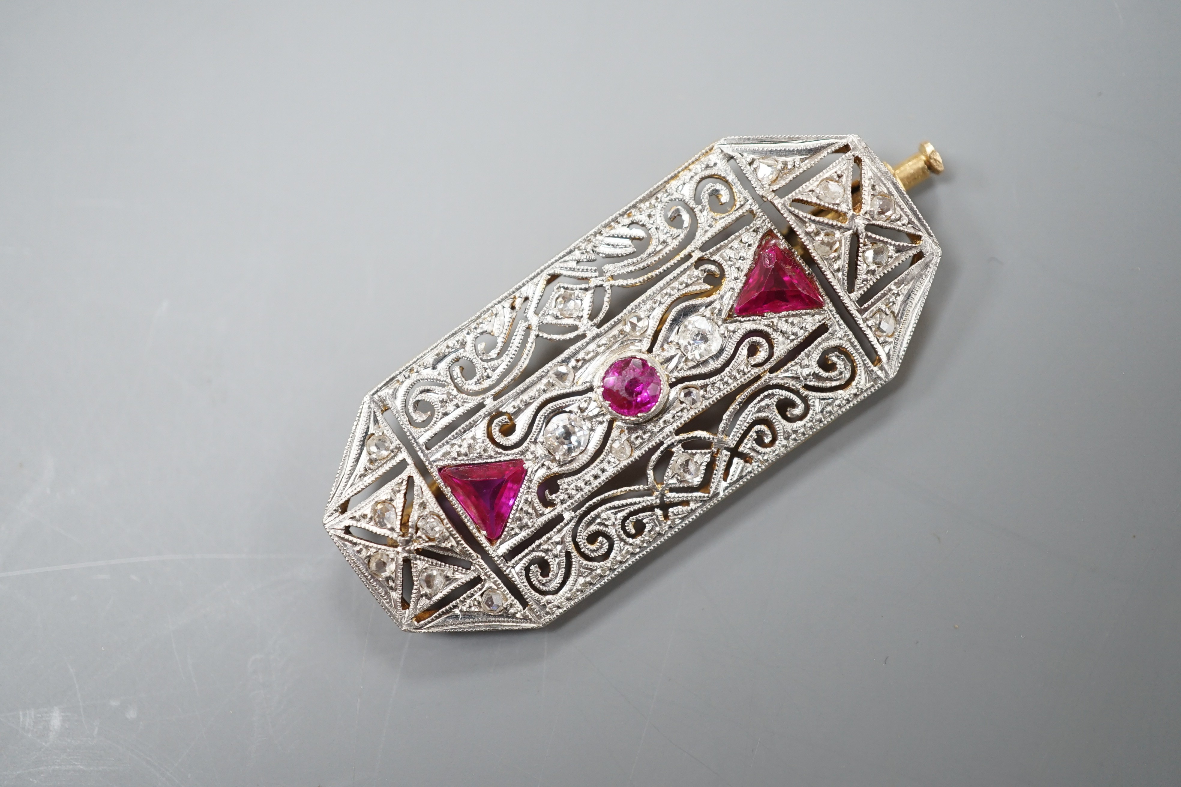 A yellow and white metal, synthetic ruby? and millegrain set diamond octagonal brooch, 40mm, gross weight 7.7 grams.